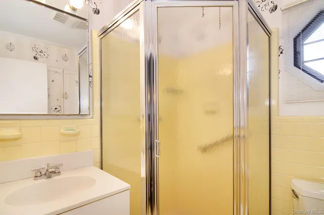 a bathroom with a sink mirror and shower