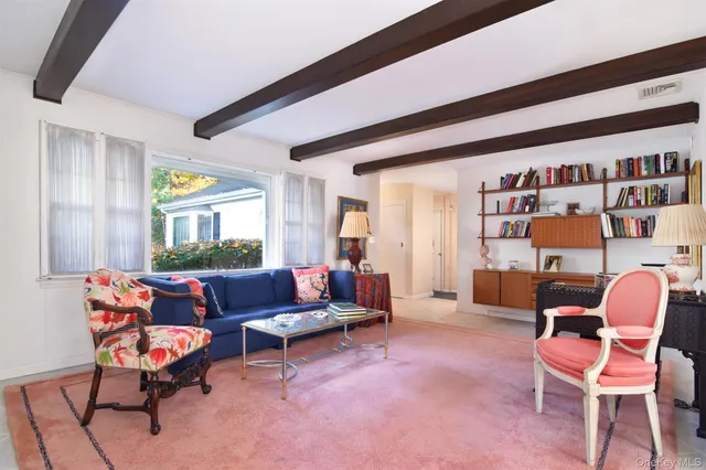 a living room with furniture a rug and a large window