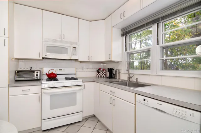 a kitchen with granite countertop white cabinets and white appliances