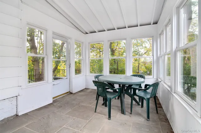 a dining room with furniture and large windows