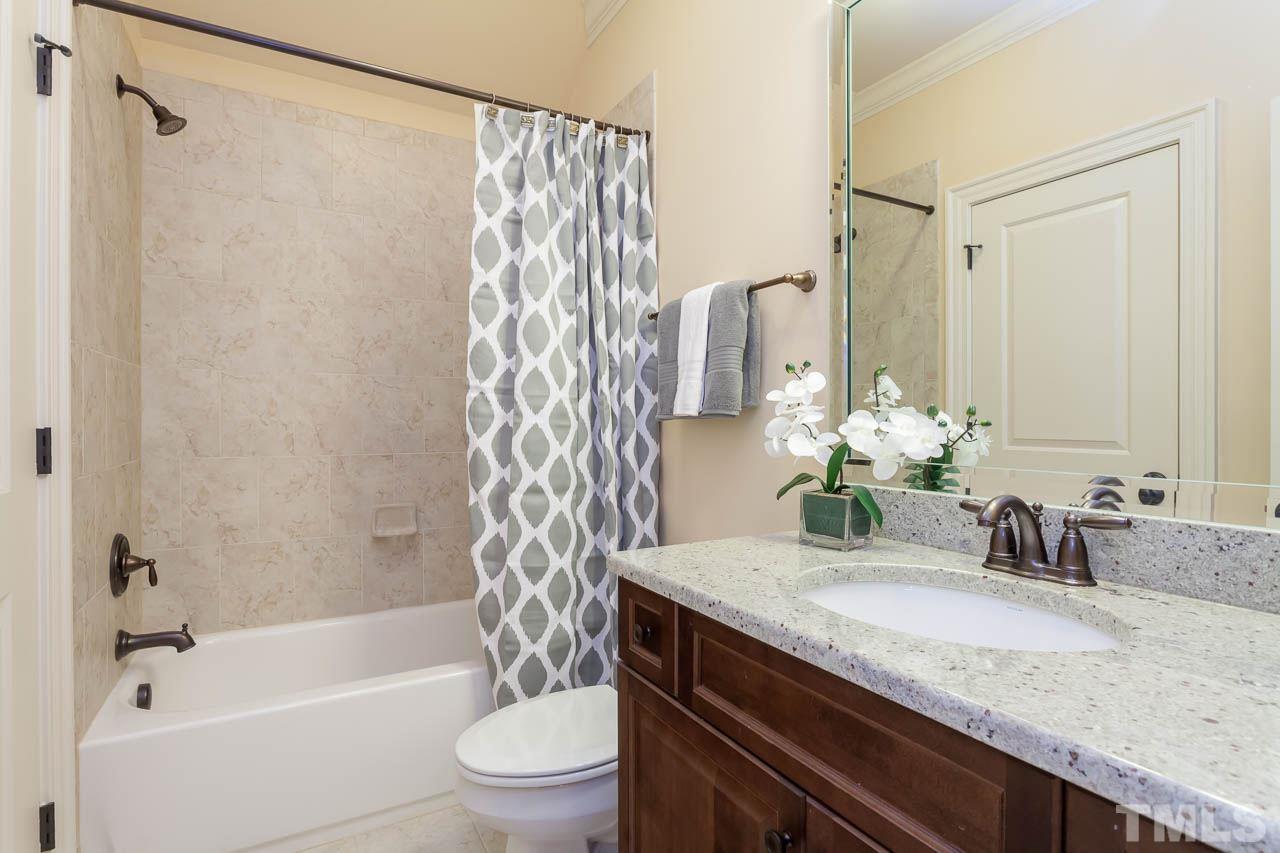 821 Keith Road Wake Forest, NC 27587 - Photo 14 of 25 This well appointed bath has direct access to bedroom #2 and is also the bath for bedroom #3 It features a tub/shower combination with tile surround and vanity with a granite counter top.