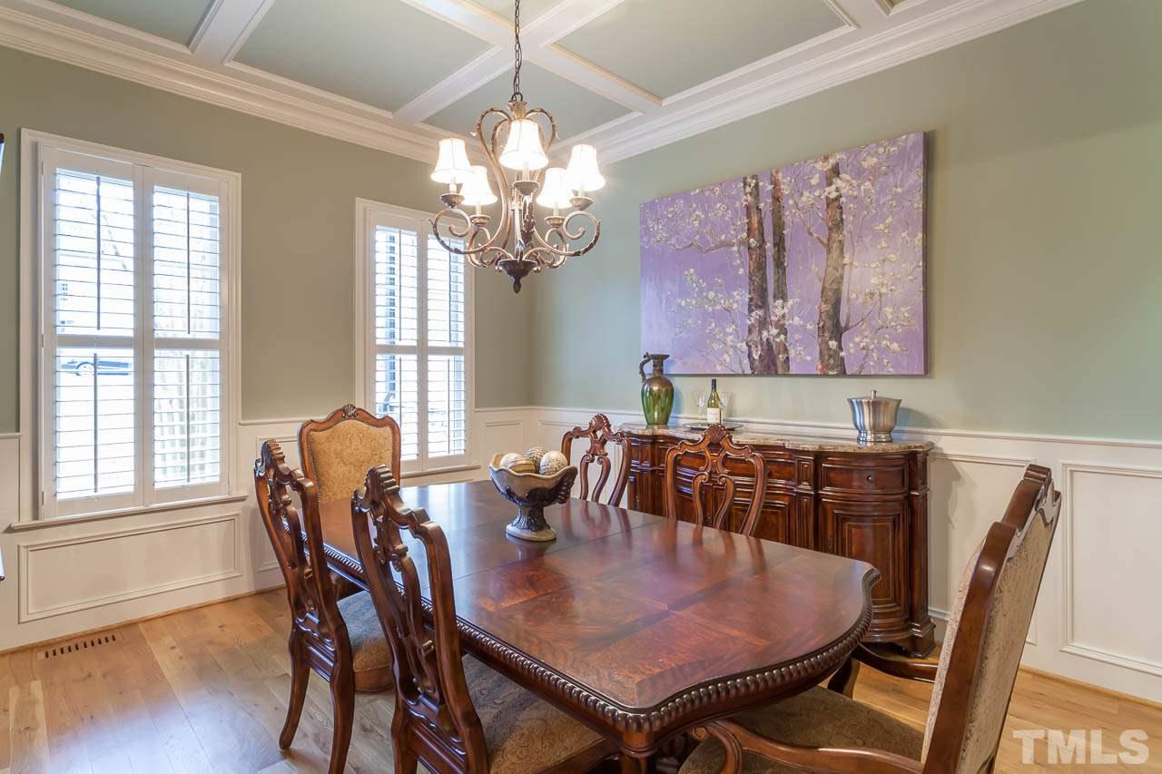 821 Keith Road Wake Forest, NC 27587 - Photo 3 of 25 A coffered ceiling graces the dining room. Additional features include plantation shutters, hardwood floors, wainscoting, and chair railing. The dining room adjoins a butler's pantry that leads to the kitchen.