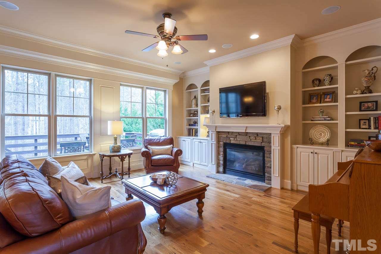 821 Keith Road Wake Forest, NC 27587 - Photo 7 of 25 The family room features double bookcases that frame the gas fireplace. It overlooks the beautiful backyard and features hardwood floors, a ceiling fan, crown molding, and recessed lighting.