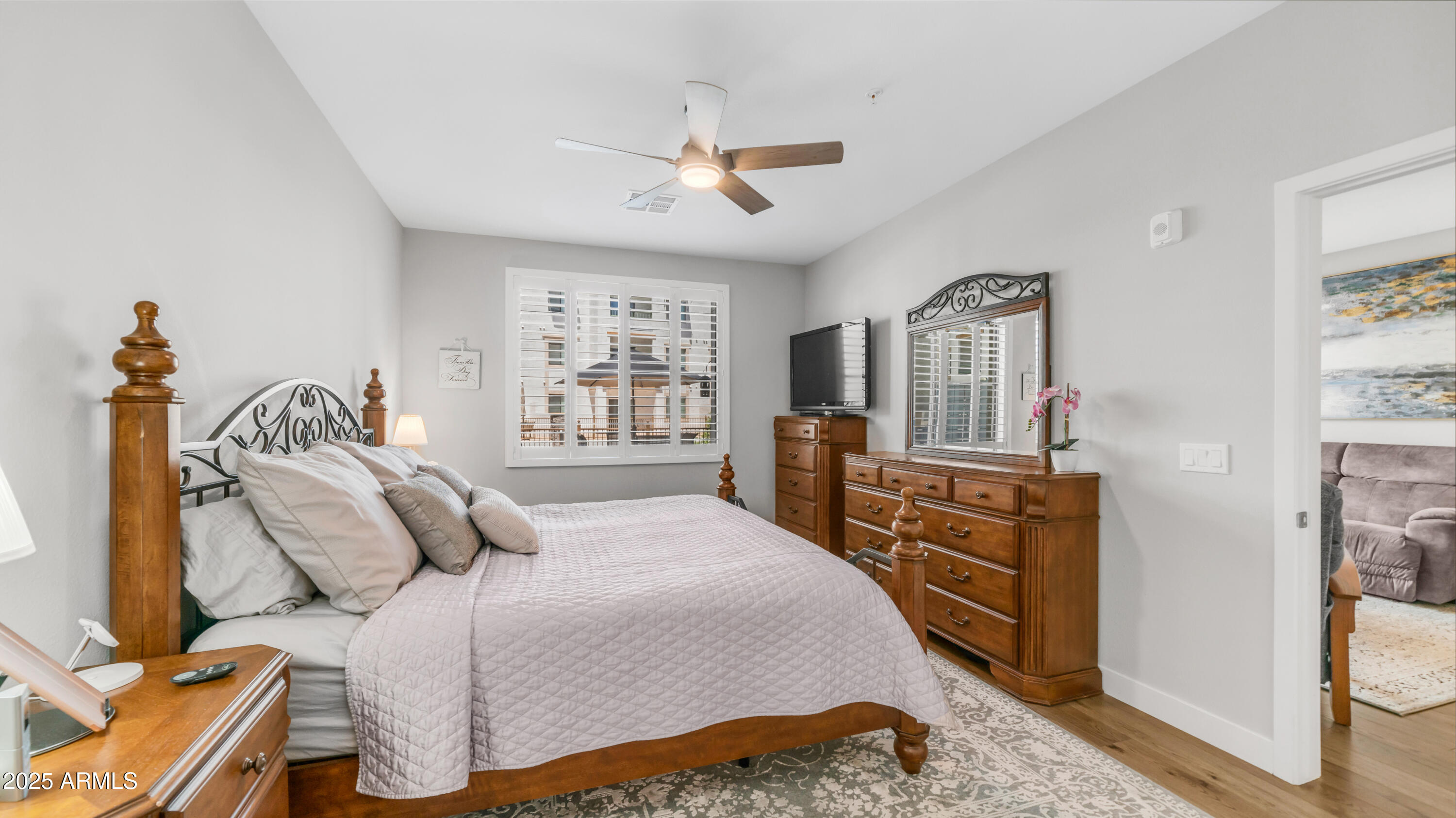 2511 West Queen Creek Road, Unit 166 Chandler, AZ 85248 - Photo 18 of 66 a bedroom with a bed a dresser and potted plants with the wooden floor