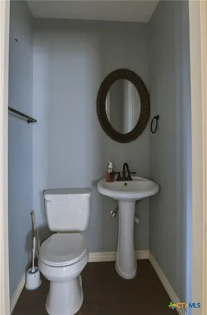 a bathroom with a toilet sink and mirror