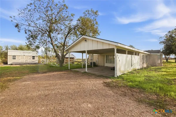 a view of a house with backyard and trees