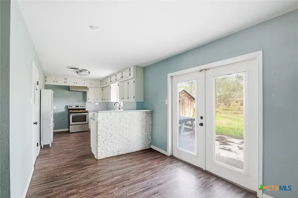 a view of a kitchen with furniture and wooden floor