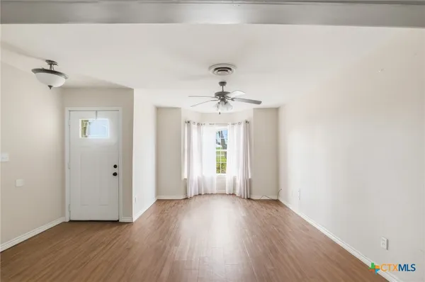 wooden floor in an empty room with a window