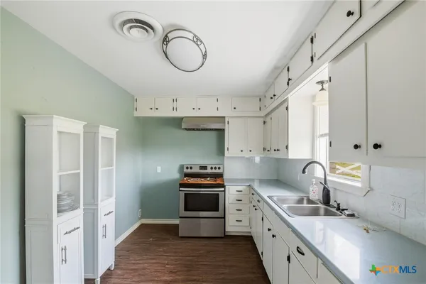 a kitchen with granite countertop a sink stainless steel appliances and cabinets