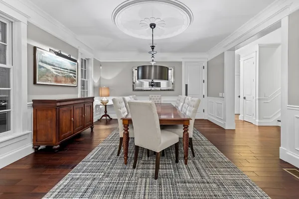 a dining room with furniture wooden floor a rug and a chandelier