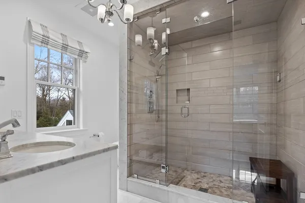 a bathroom with a shower sink and mirror