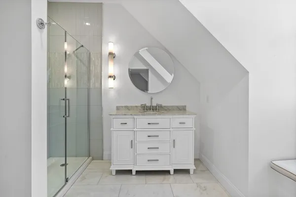 a bathroom with a granite countertop sink a mirror and a vanity