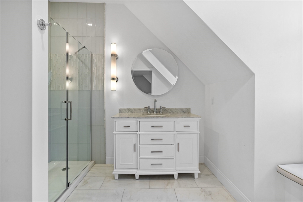 75 Goddard Avenue Brookline, MA 02445 - Photo 25 of 27 a bathroom with a granite countertop sink a mirror and a vanity