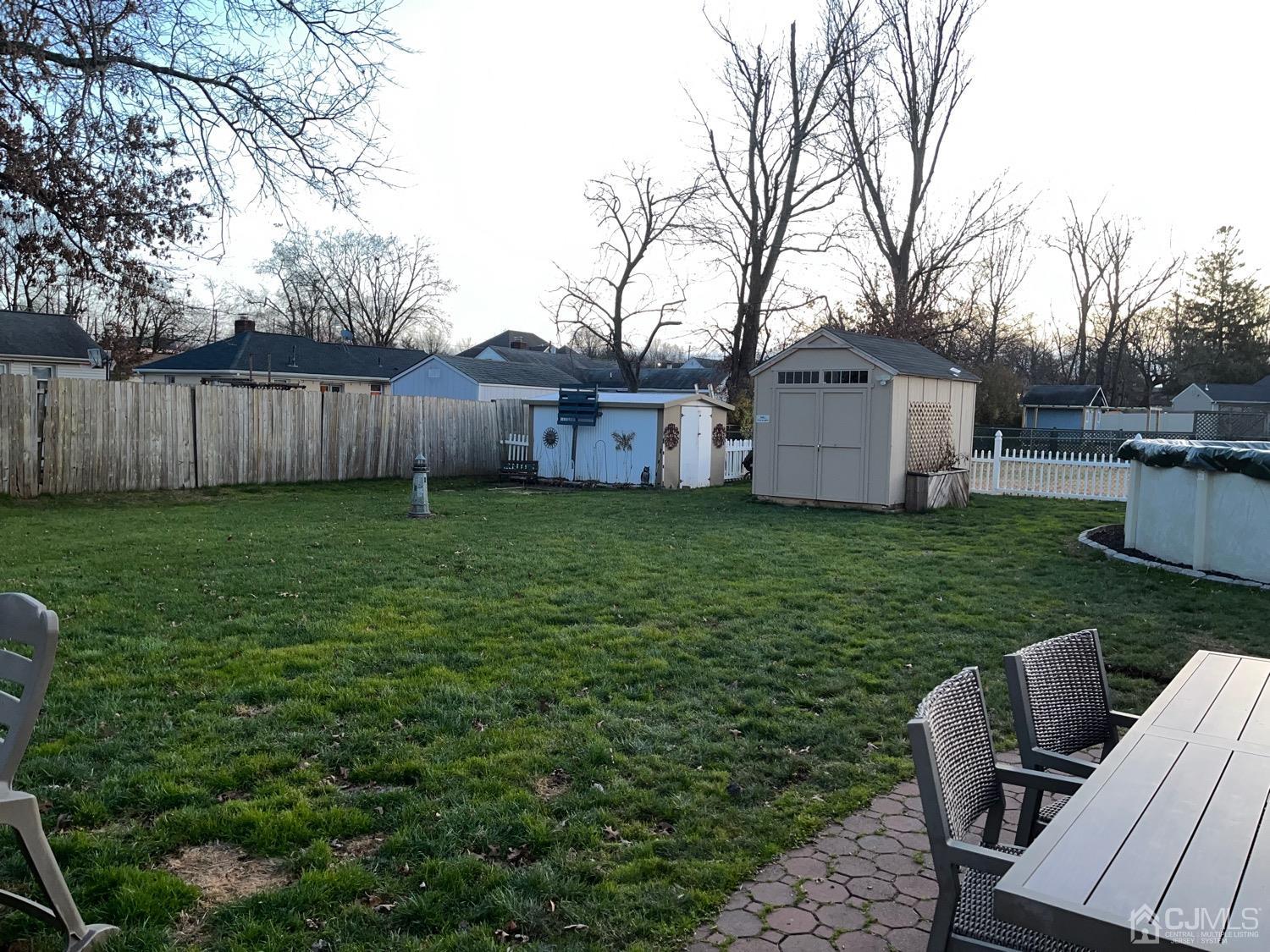 34 Dalton Place Edison, NJ 08817 - Photo 13 of 20 a view of backyard with table and chairs wooden fence and trees