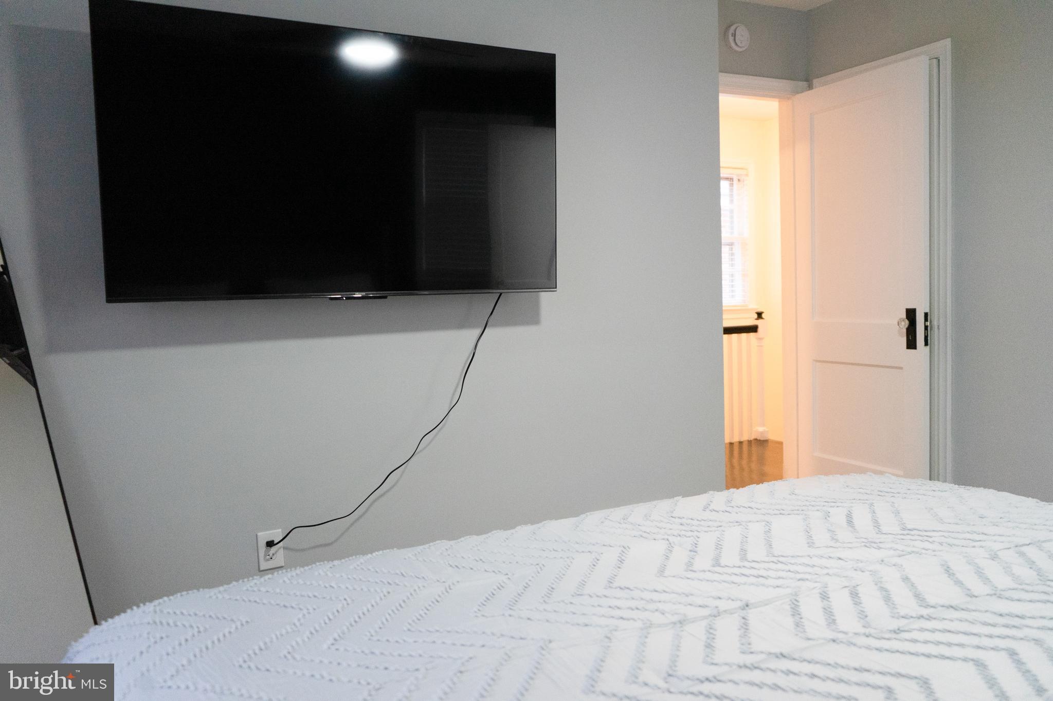 7329 12th Street Northwest Washington, DC 20012 - Photo 16 of 20 a bedroom with a bed and a flat screen tv