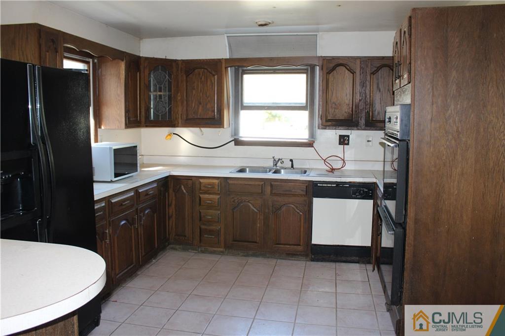 317 Ridge Road Dayton, NJ 08810 - Photo 8 of 16 a kitchen with a sink a stove and refrigerator