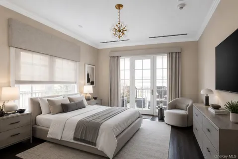 a bedroom with bed and a flat tv screen on dresser