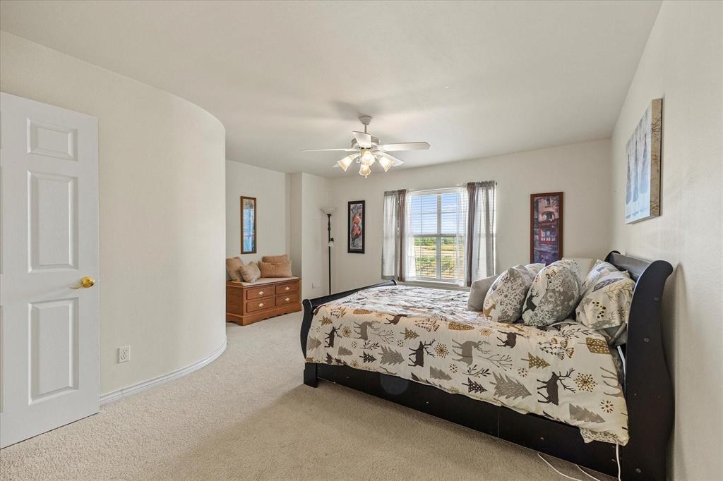 3399 Peterson Road South Iowa Park, TX 76367 - Photo 34 of 40 a bedroom with a large bed and a chandelier