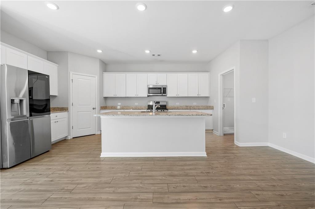 4646 Waxwing Street Hoschton, GA 30548 - Photo 11 of 36 a view of kitchen with stainless steel appliances granite countertop a stove a sink and a microwave