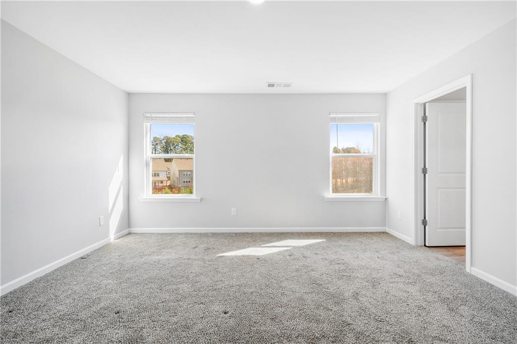4646 Waxwing Street Hoschton, GA 30548 - Photo 16 of 36 an empty room with windows