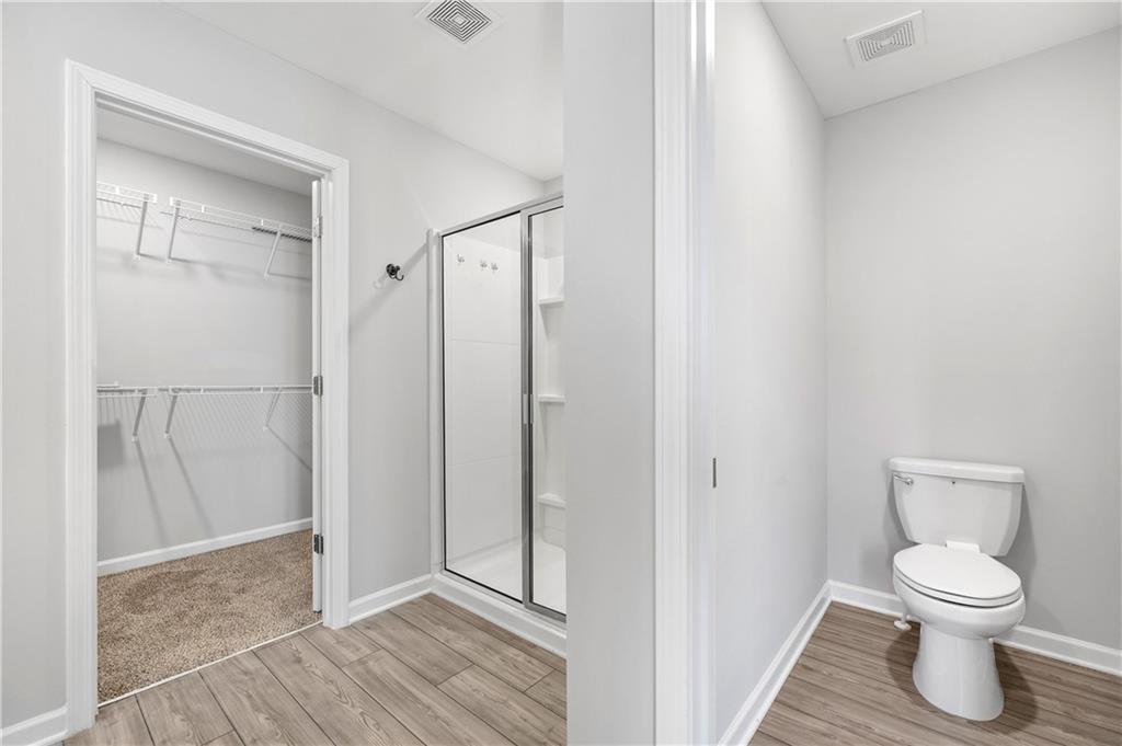 4646 Waxwing Street Hoschton, GA 30548 - Photo 20 of 36 a bathroom with a toilet and a shower