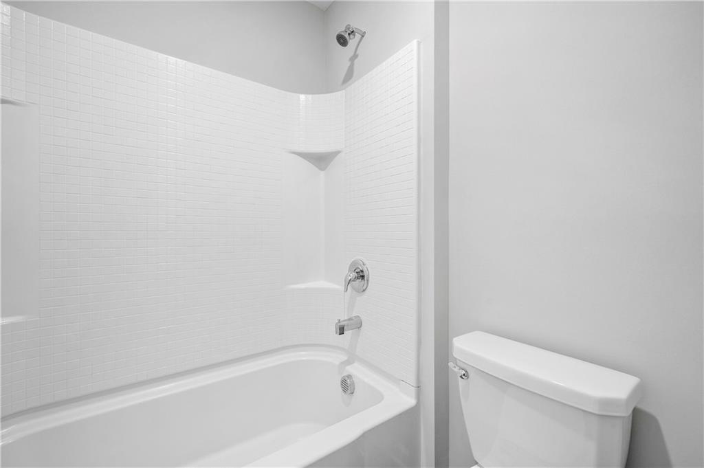 4646 Waxwing Street Hoschton, GA 30548 - Photo 28 of 36 a bathroom with a bathtub and a toilet