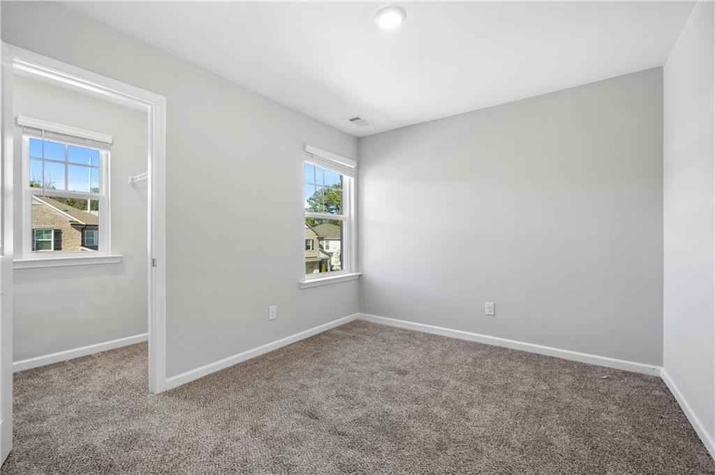 4646 Waxwing Street Hoschton, GA 30548 - Photo 31 of 36 an empty room with windows