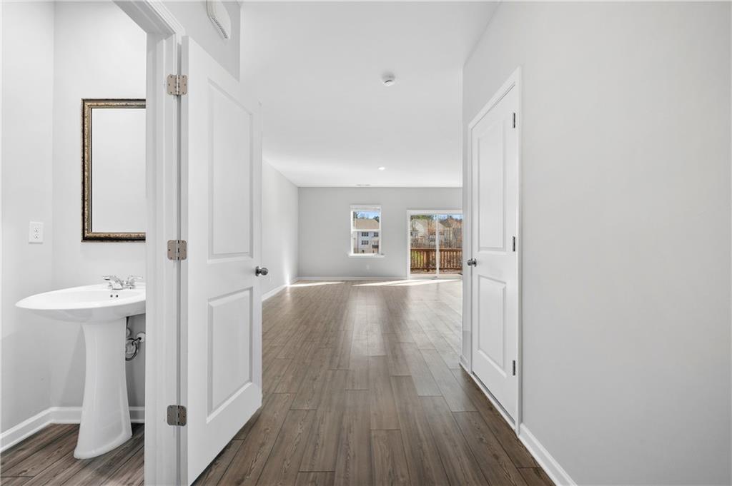 4646 Waxwing Street Hoschton, GA 30548 - Photo 6 of 36 a view of a hallway with wooden floor and staircase