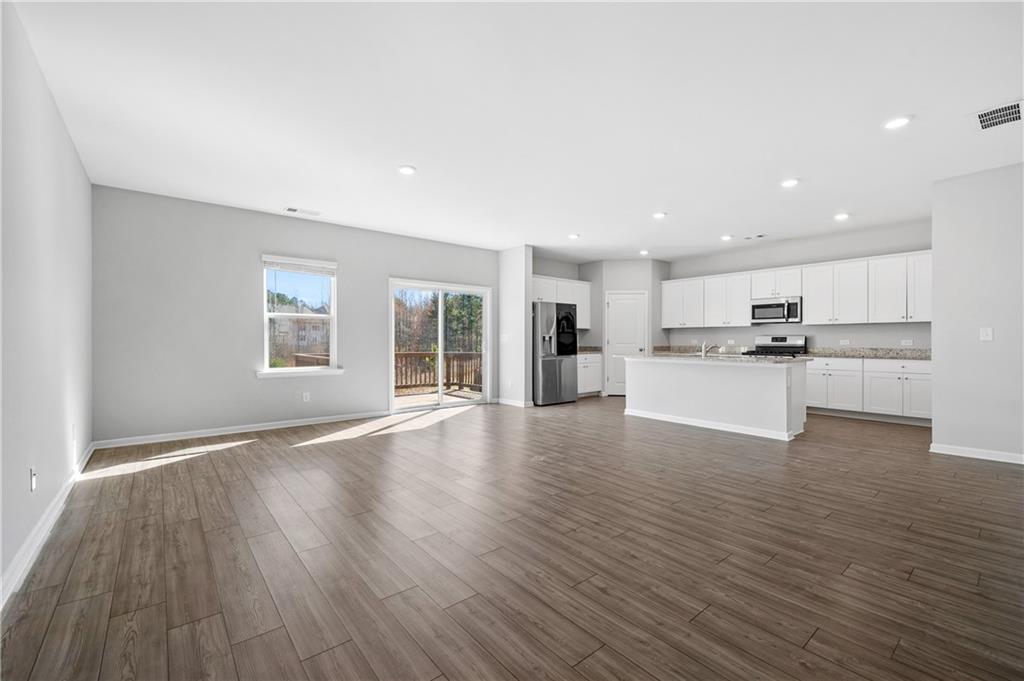 4646 Waxwing Street Hoschton, GA 30548 - Photo 8 of 36 a view of kitchen with wooden floor and electronic appliances