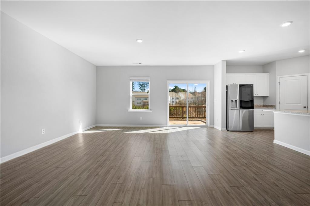 4646 Waxwing Street Hoschton, GA 30548 - Photo 9 of 36 a view of wooden floor and windows in a room