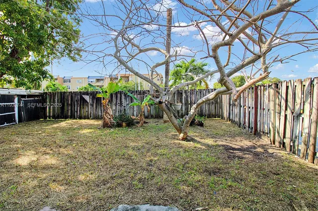 a backyard of a house with table and chairs