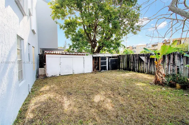 a backyard of a house with plants and tree