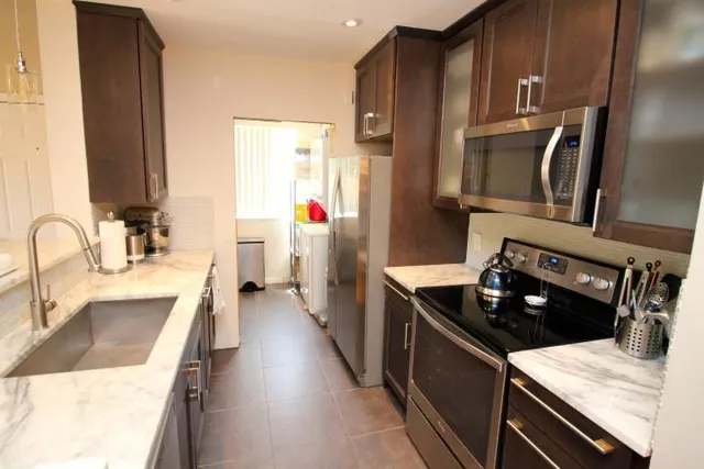 a kitchen with stainless steel appliances granite countertop a sink stove and refrigerator