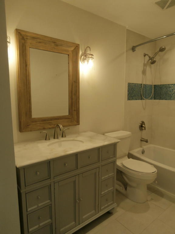 157 Yacht Club Way, Unit 201 CORNER Hypoluxo, FL 33462 - Photo 12 of 24 a bathroom with a sink toilet vanity and shower