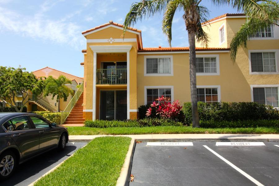 157 Yacht Club Way, Unit 201 CORNER Hypoluxo, FL 33462 - Photo 14 of 24 a front view of a house with a garden and trees