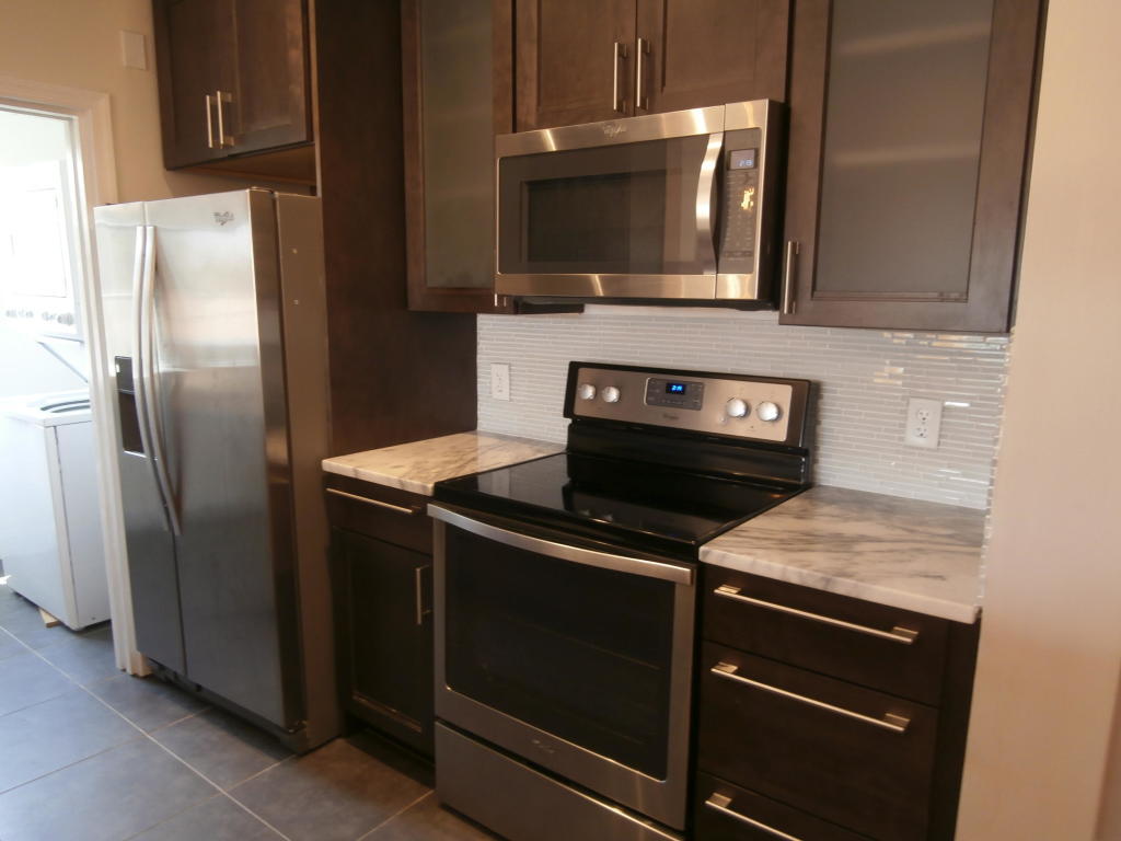 157 Yacht Club Way, Unit 201 CORNER Hypoluxo, FL 33462 - Photo 3 of 24 a kitchen with a stove microwave and refrigerator