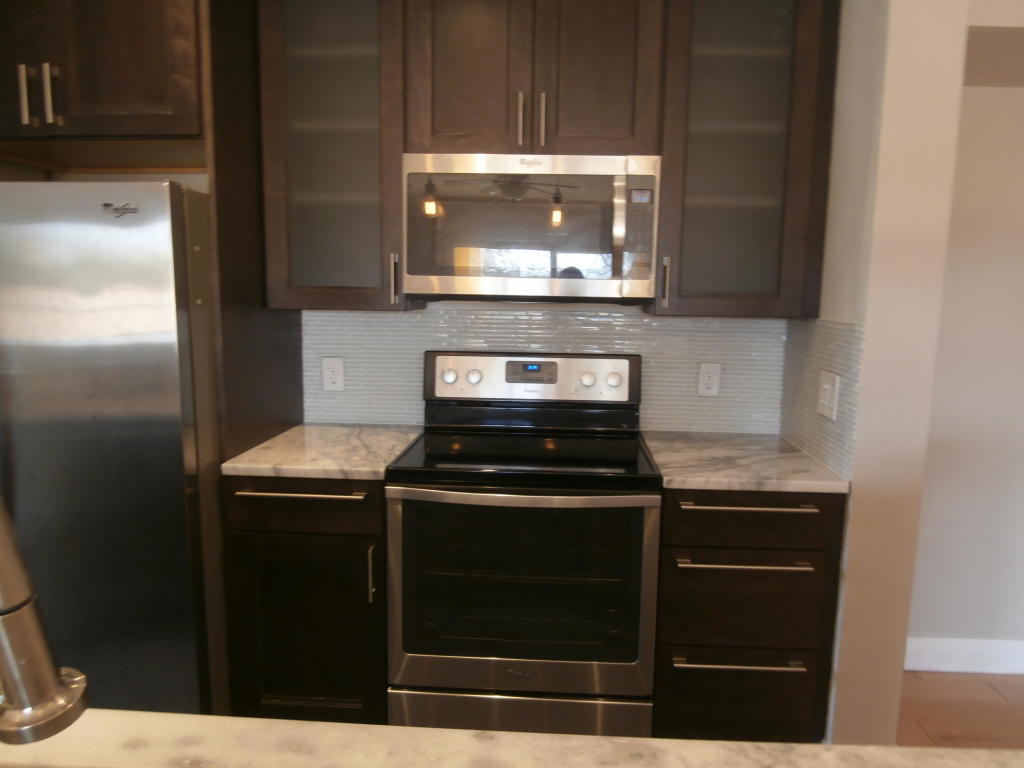 157 Yacht Club Way, Unit 201 CORNER Hypoluxo, FL 33462 - Photo 5 of 24 a kitchen with a stove and a microwave