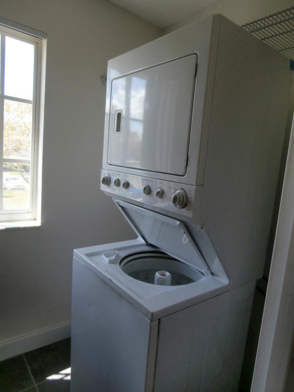 157 Yacht Club Way, Unit 201 CORNER Hypoluxo, FL 33462 - Photo 6 of 24 a utility room with wooden floor washer and dryer
