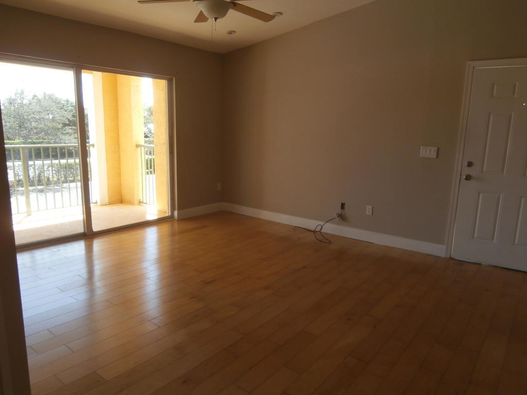157 Yacht Club Way, Unit 201 CORNER Hypoluxo, FL 33462 - Photo 9 of 24 a view of room with window and wooden floor