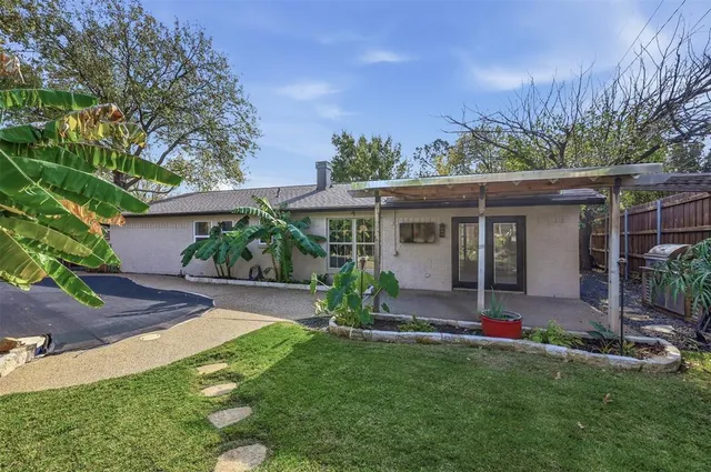 front view of a house with a yard and potted plants