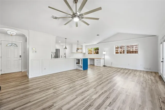 a view of a kitchen with wooden floor and a ceiling fan