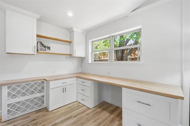 a view of a kitchen with wooden floor and cabinets