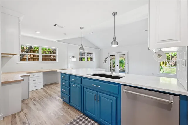 a kitchen with stainless steel appliances granite countertop a sink a window and wooden floor