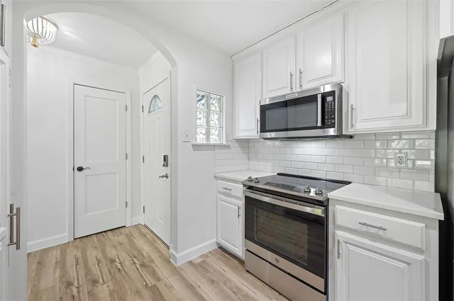 a kitchen with granite countertop cabinets stainless steel appliances and wooden floor