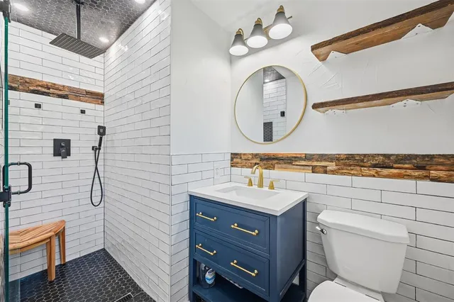 a bathroom with a toilet a sink and mirror