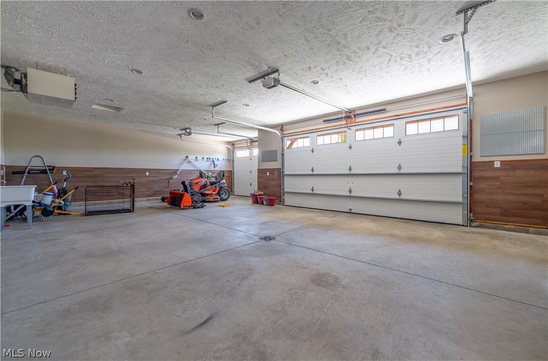 3515 Eastport Road Southeast Dennison, OH 44621 - Photo 41 of 41 Spacious garage featuring concrete flooring, a dual overhead door with translucent panels, and a single overhead door with translucent panels