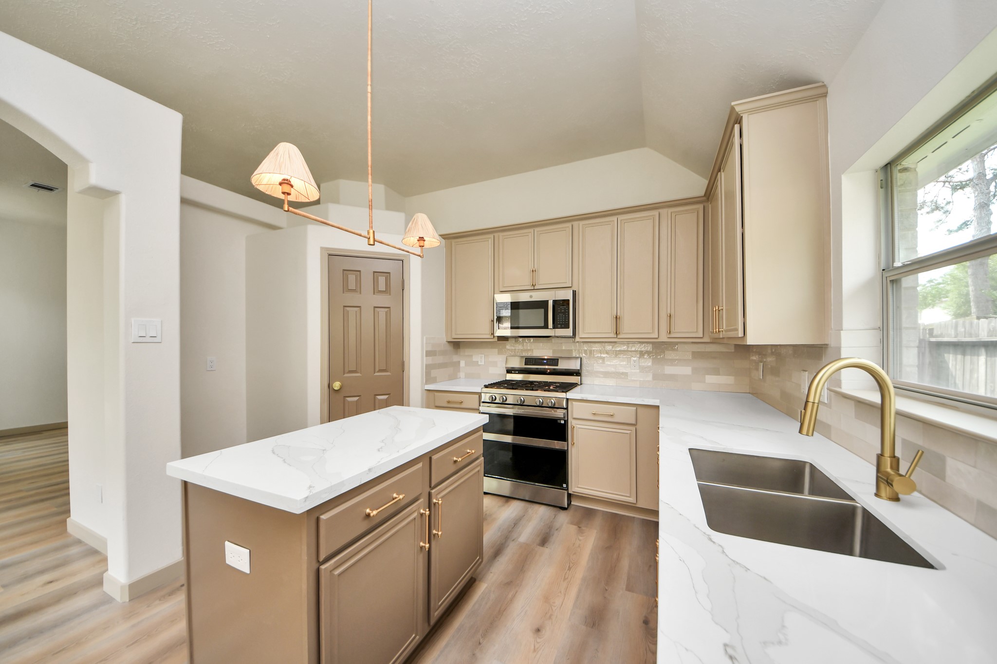 14423 Gadwall Court Houston, TX 77044 - Photo 27 of 42 a kitchen with a sink a stove a refrigerator cabinets and a window