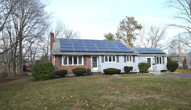 a view of a house with a yard and large trees