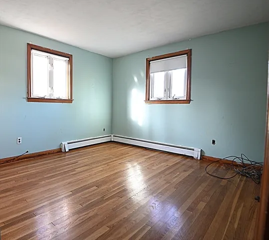 a view of a room with wooden floor and window