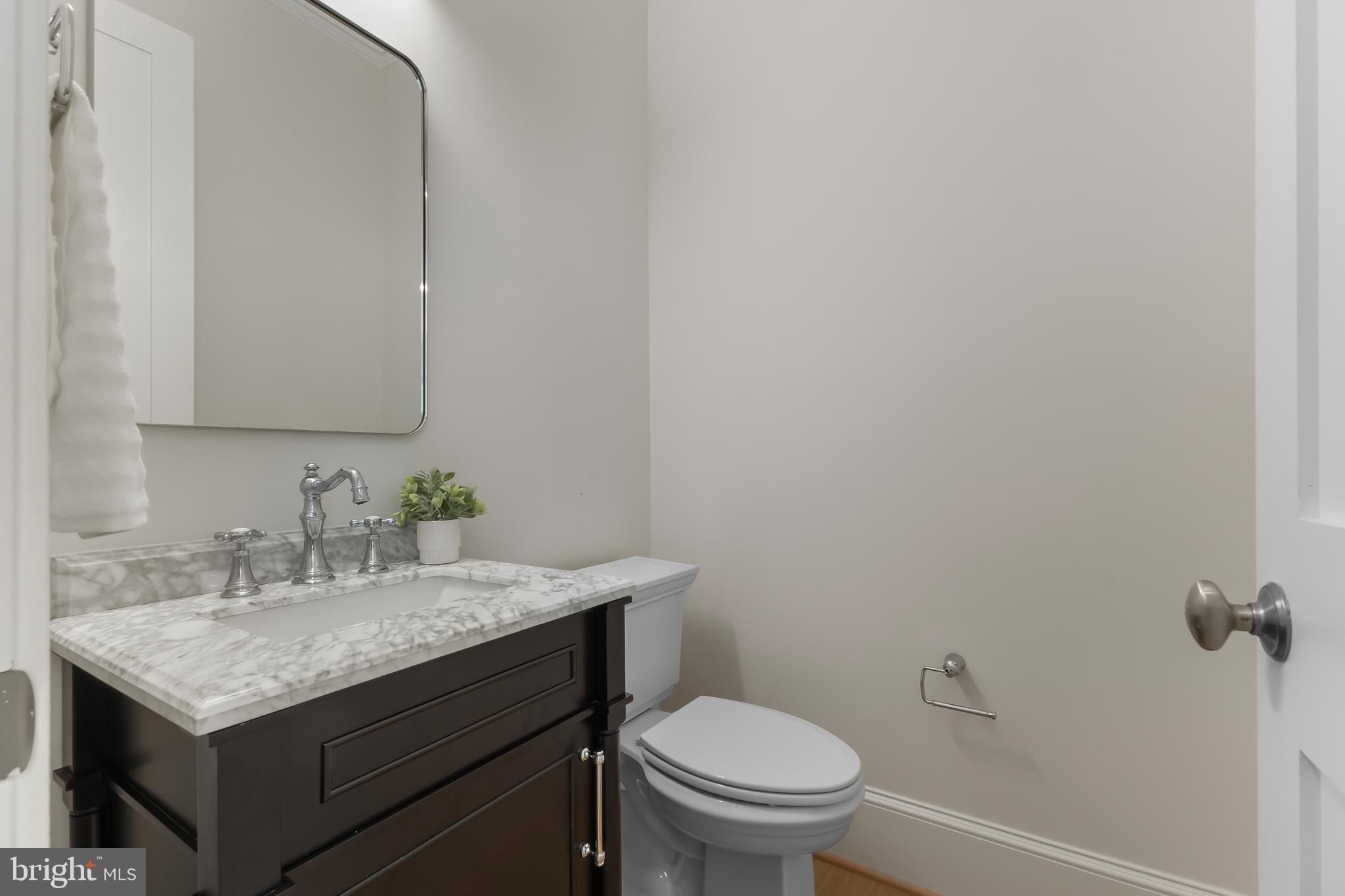 8628 Plymouth Road Alexandria, VA 22308 - Photo 26 of 50 a bathroom with a granite countertop toilet sink and mirror